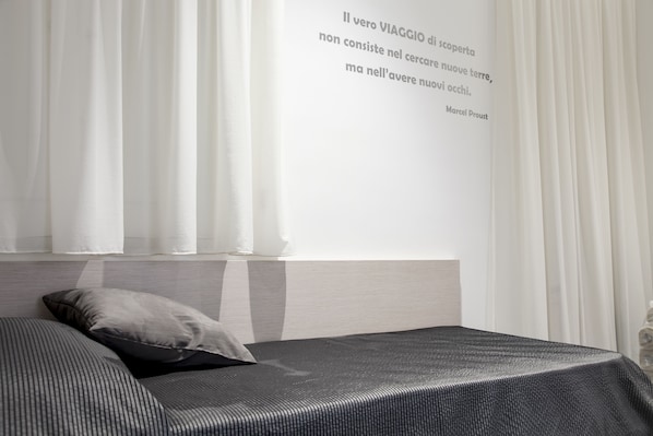Un dormitorio moderno con cama, almohada y una cita en la pared.