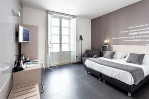 Un dormitorio moderno con una cama grande, un escritorio con una computadora, una lámpara de pie y una pared con una cita motivacional.