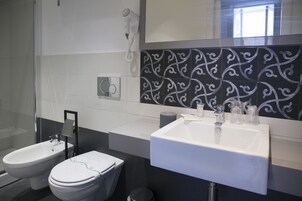 Ein modernes Badezimmer mit einer Bidet-Funktion, Toilette und einem großen Waschbecken.