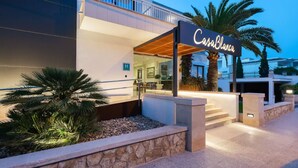 A modern hotel with a sign reading "Casa Blanca." It features a stone facade, a covered entrance, and a palm tree in the foreground. -  Hotel Casablanca Mallorca (Calvia)