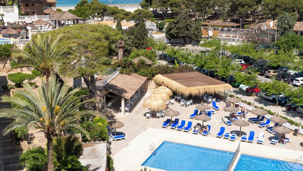 A resort with a swimming pool, lounge chairs, and a view of the sea. -  Hotel Casablanca Mallorca (Calvia)