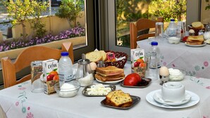 Een ontbijttafel met verschillende soorten eten, zoals brood, eieren en een waterfles.