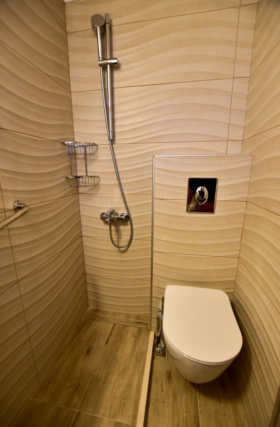 A small, enclosed shower stall with a toilet and a showerhead.