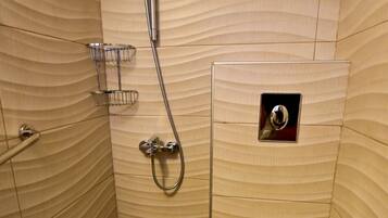A small, enclosed shower stall with a toilet and a showerhead.