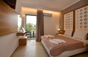 Una habitación de hotel con cama, escritorio, silla, balcón y aire acondicionado.