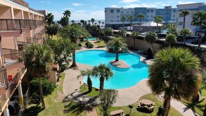 Un hotel con piscina rodeado de palmeras y vistas al océano.