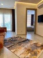Una sala moderna con un sofá, un tapete estampado y una televisión.