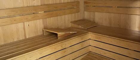 Una sauna de madera con bancos dispuestos en zigzag.
