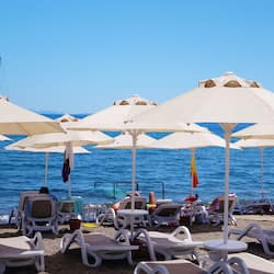 Am Strand, Liegestühle, Sonnenschirme, Strandtücher