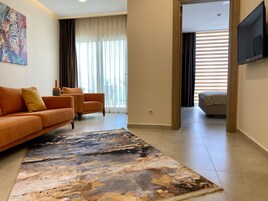 Una sala de estar moderna con un sofá, sillones y una alfombra grande.