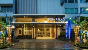 The exterior of the Aston Solo Hotel with a modern design, featuring a prominent entrance, a well-lit facade, and a landscaped area with decorative lighting. - Aston Solo (Surakarta)