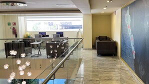 A modern lobby with a glass railing, a reception desk, computers, and a large abstract painting on the wall. - Holiday Inn Express Culiacan by IHG (Culiacán)