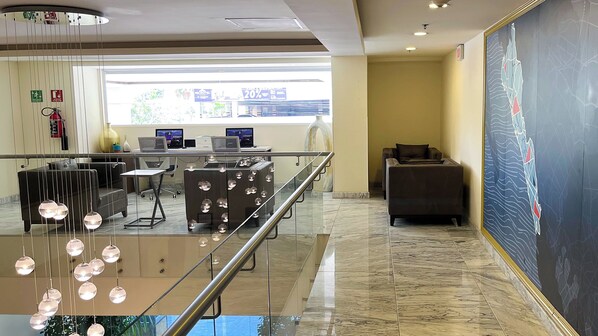 A modern lobby with a glass railing, a reception desk, computers, and a large abstract painting on the wall. - Holiday Inn Express Culiacan by IHG (Culiacán)