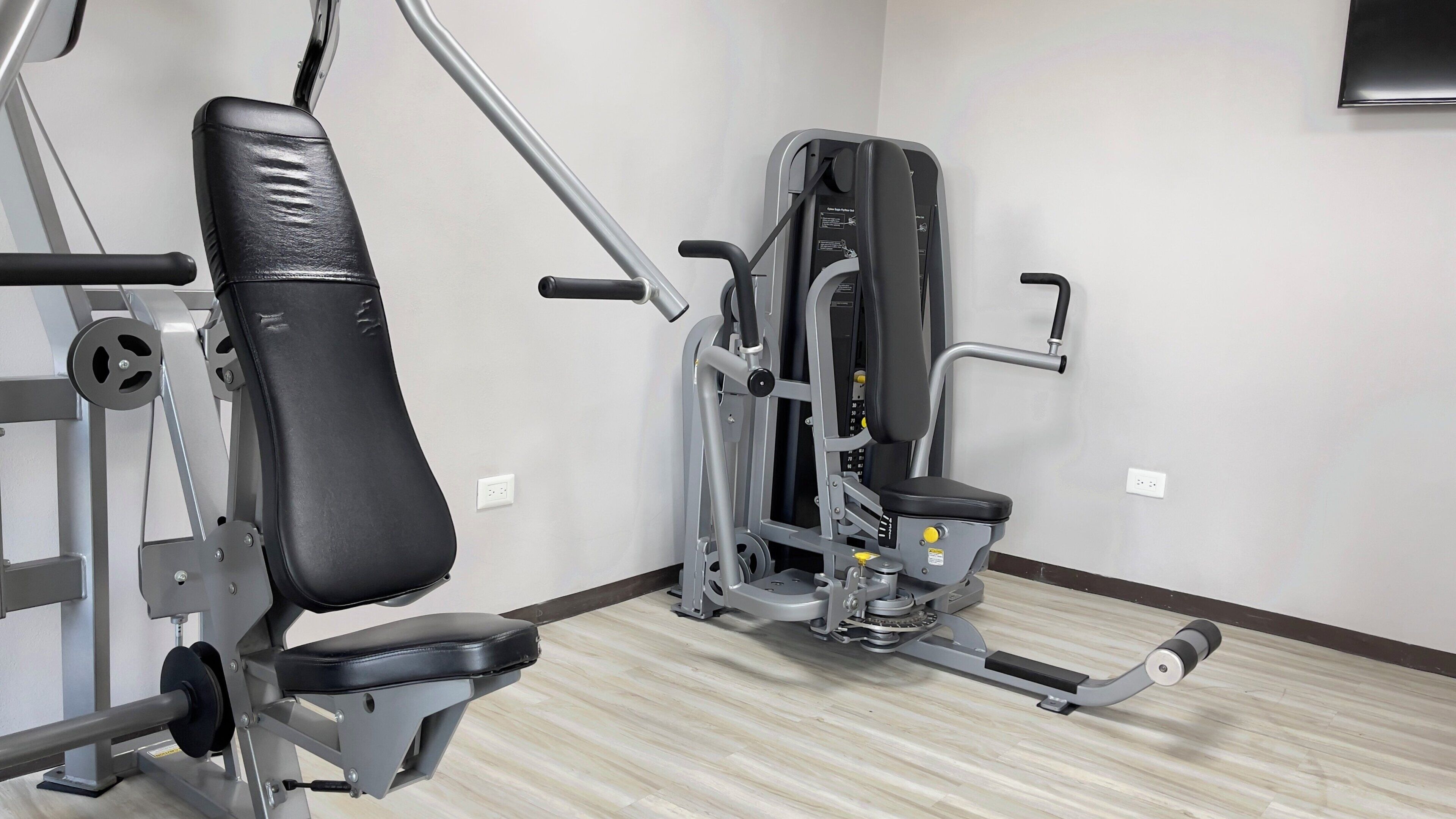 A gym with exercise equipment, including a bench and a weight machine.
