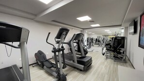 A gym with treadmills, elliptical machines, and weight equipment.