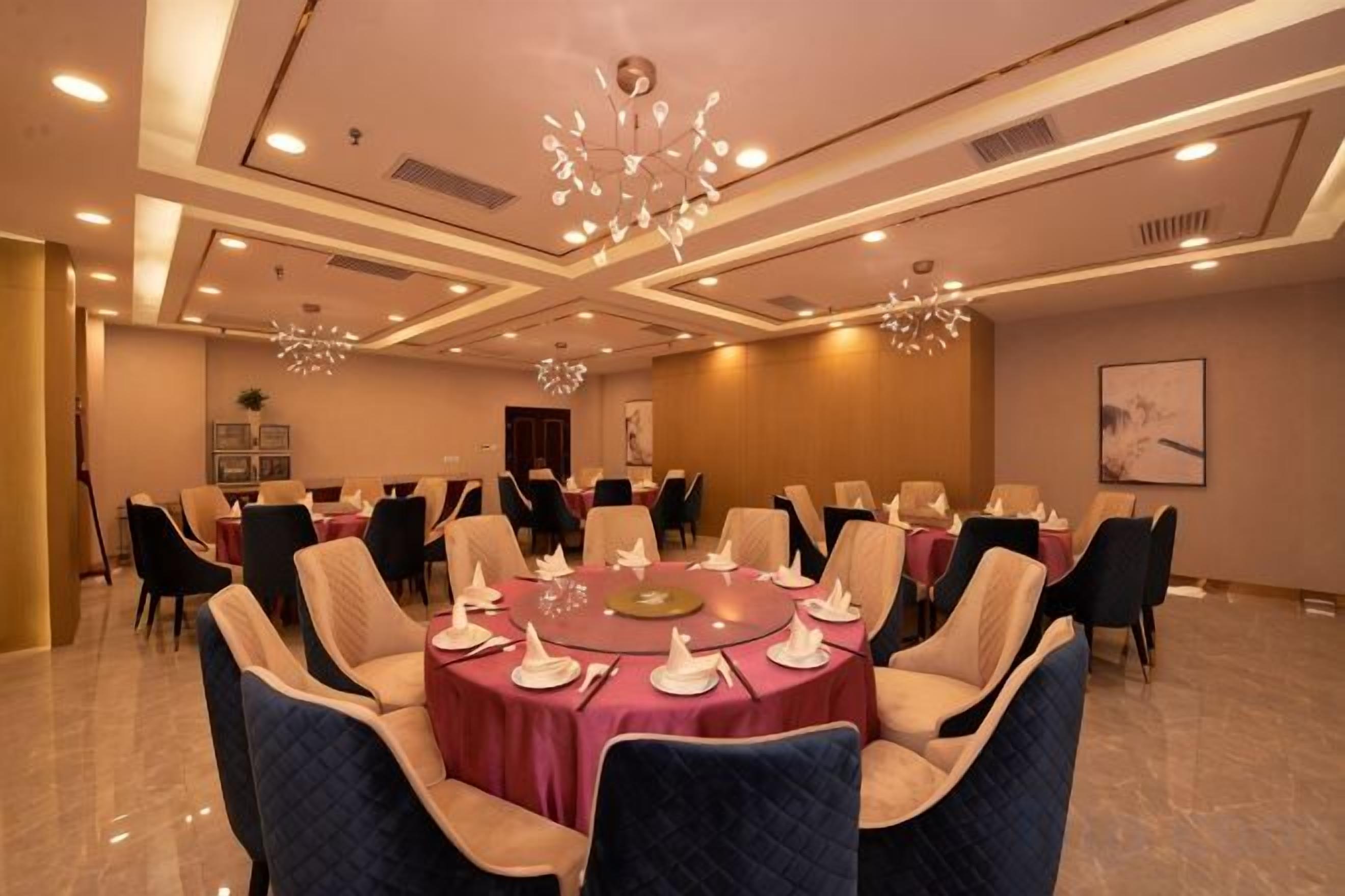 A conference room with round tables, chairs, and a chandelier.