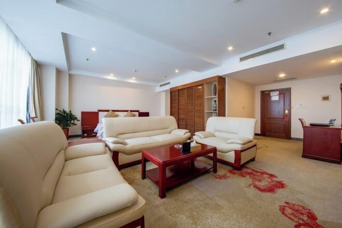 Une chambre d’hôtel comprenant un canapé, un meuble en bois et un bureau.