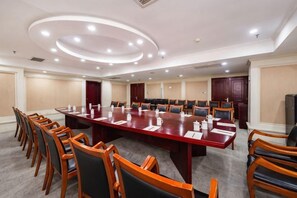 A conference room with a long table, chairs, and a television. - Guangming Hotel (Weinan)