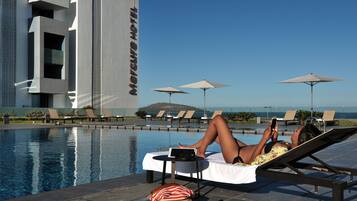 Piscine couverte, piscine extérieure, parasols de plage, chaises longues