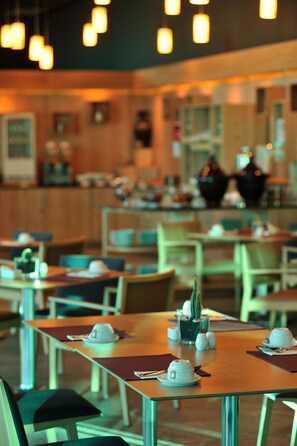 A restaurant with tables set for dining, featuring a cactus centerpiece and white cups. - Hotel Mercure Rif Nador (Nador)
