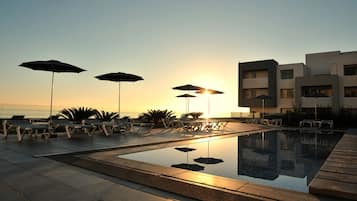 Piscine couverte, piscine extérieure, parasols de plage, chaises longues