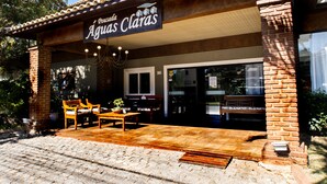 A restaurant with a patio area, outdoor seating, and a sign reading "Pousada Aguias Claras".