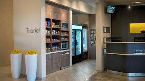 A modern interior with a reception desk, a refrigerator, and shelves stocked with snacks. - Courtyard by Marriott Philadelphia Lansdale (Harleysville)