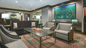 A hotel lobby with a sofa, armchairs, a glass coffee table, and a large map on the wall. - TownePlace Suites by Marriott Seguin (Seguin)