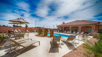 Relax by the pool surrounded by lounge chairs and umbrellas.