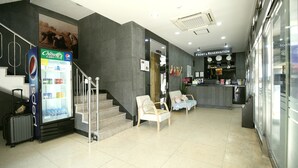 A hotel lobby with a Pepsi refrigerator, a reception desk, and a staircase. - Residence Mumum Hotel (Busan)