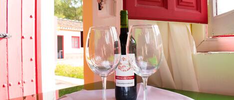 Una mesa con dos copas de vino vacías y una botella de vino.
