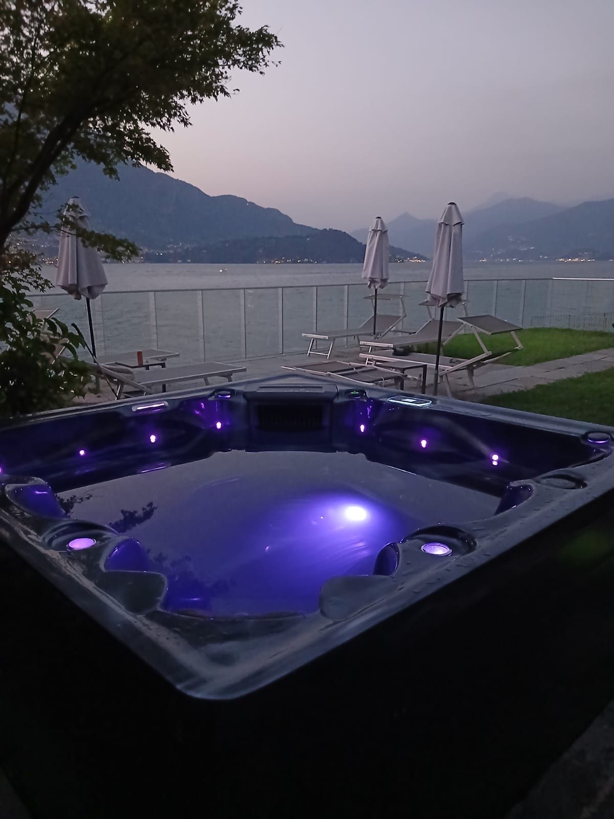 A hot tub with a view of a lake and mountains.