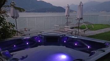 A hot tub with a view of a lake and mountains.