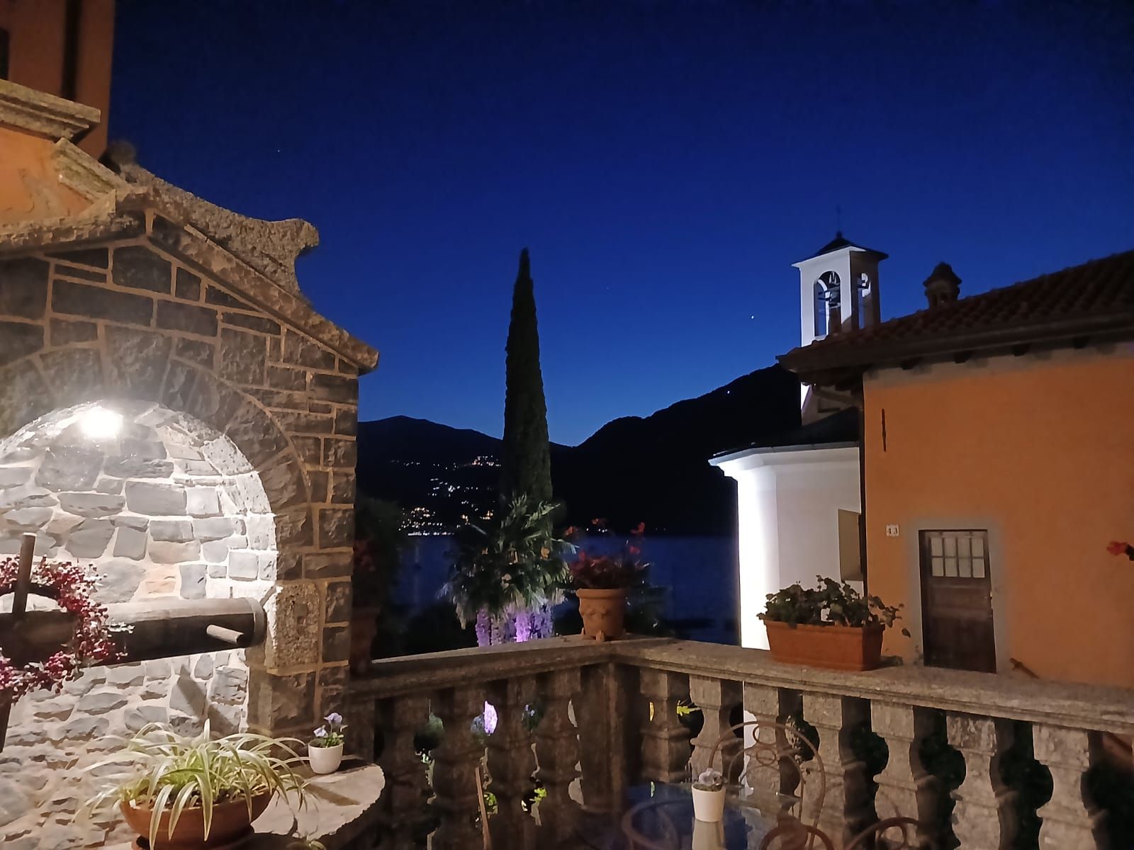 Un bâtiment en pierre doté d’un balcon donnant sur un paysage montagneux.