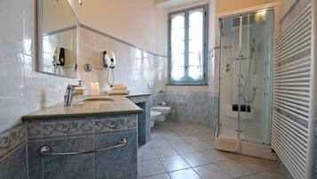 Ein Badezimmer mit Duschkabine, Waschbecken und Handtuchhalter sowie Toilette.