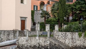 A coastal building with a bell tower, multiple windows, and a stone staircase leading to a balcony. - Palazzo del Vicerè  (Lezzeno)