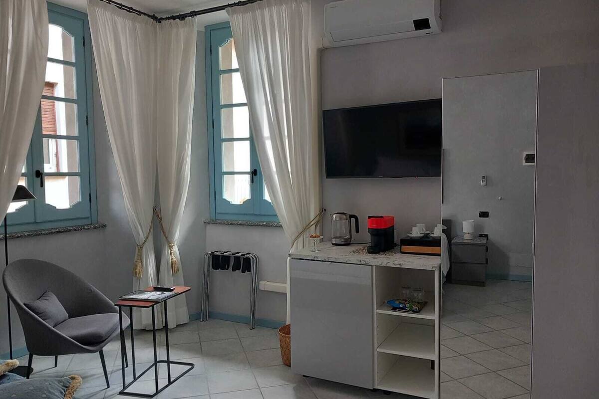 A compact room with a bed, a desk, a chair, a TV, and a wardrobe.
