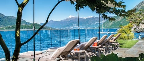 Privat strand, svart sandstrand, solstolar och parasoller