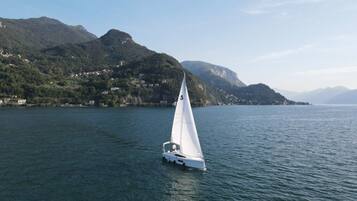 A sailboat on a calm lake with mountains in the background.