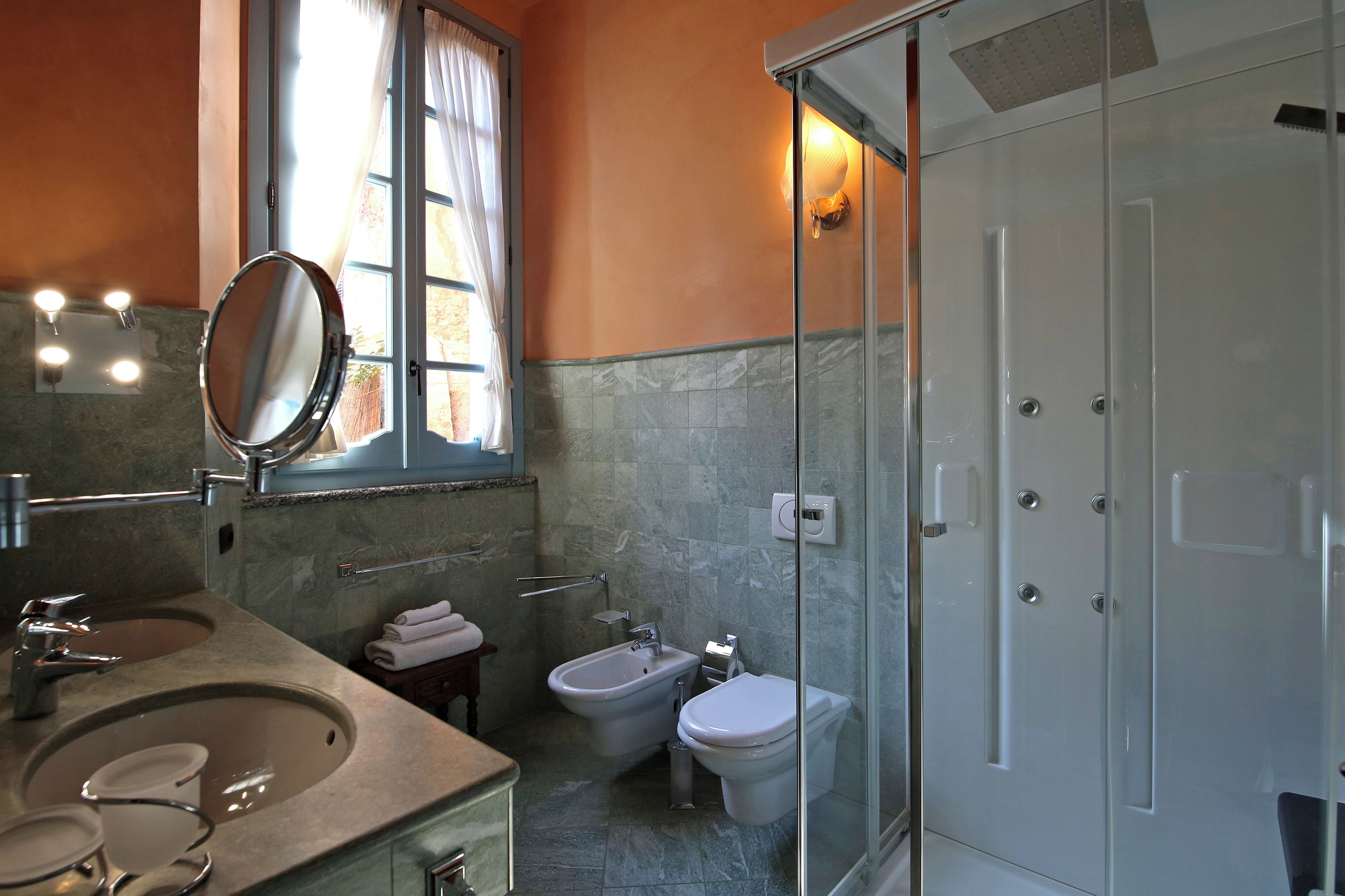 Ein Badezimmer mit Waschbecken, Spiegel, Bidet, Toilette und Duschkabine.
