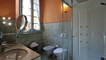 Ein Badezimmer mit Waschbecken, Spiegel, Bidet, Toilette und Duschkabine.
