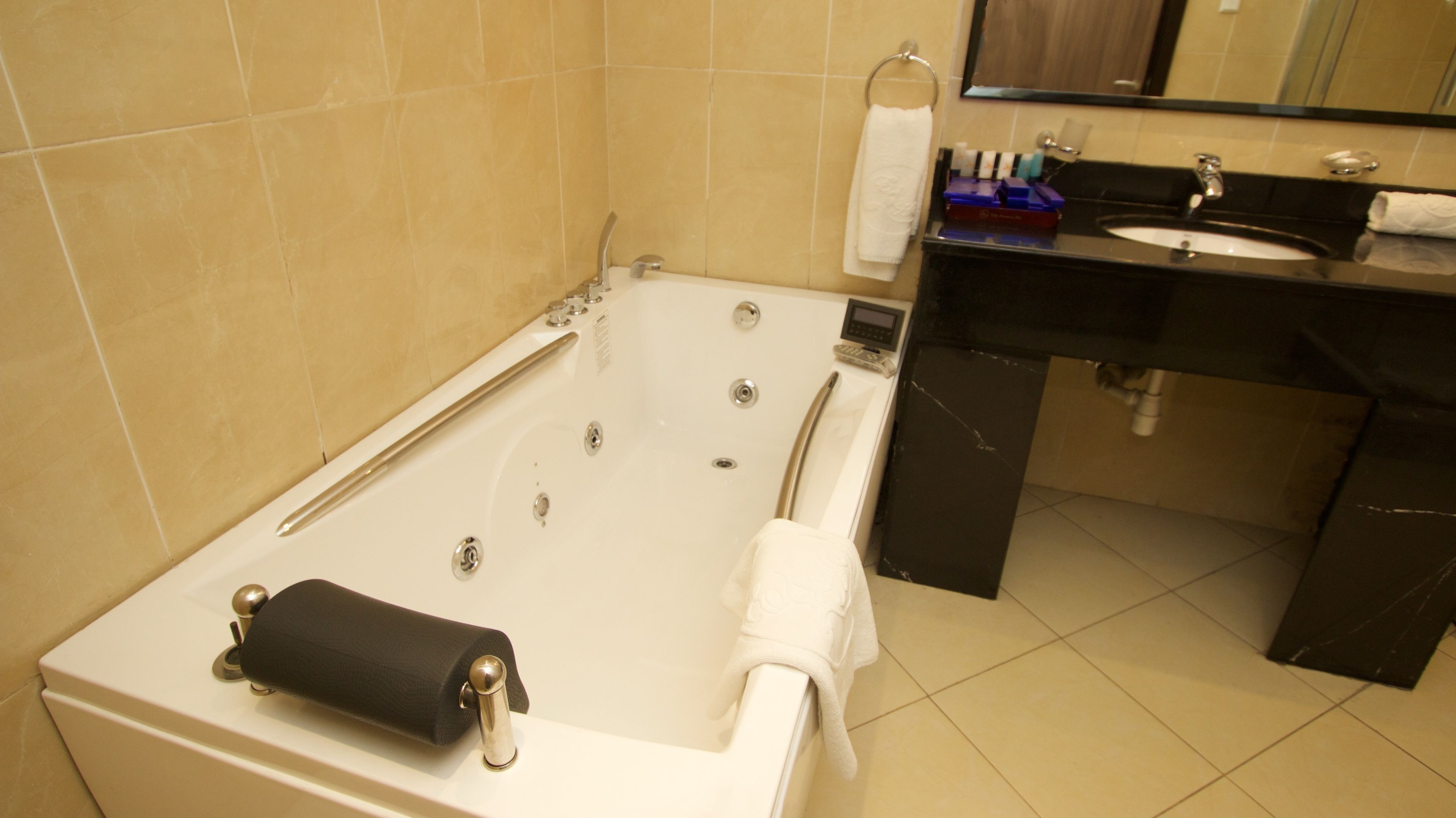 A modern bathroom with a bathtub, a sink, and a mirror.