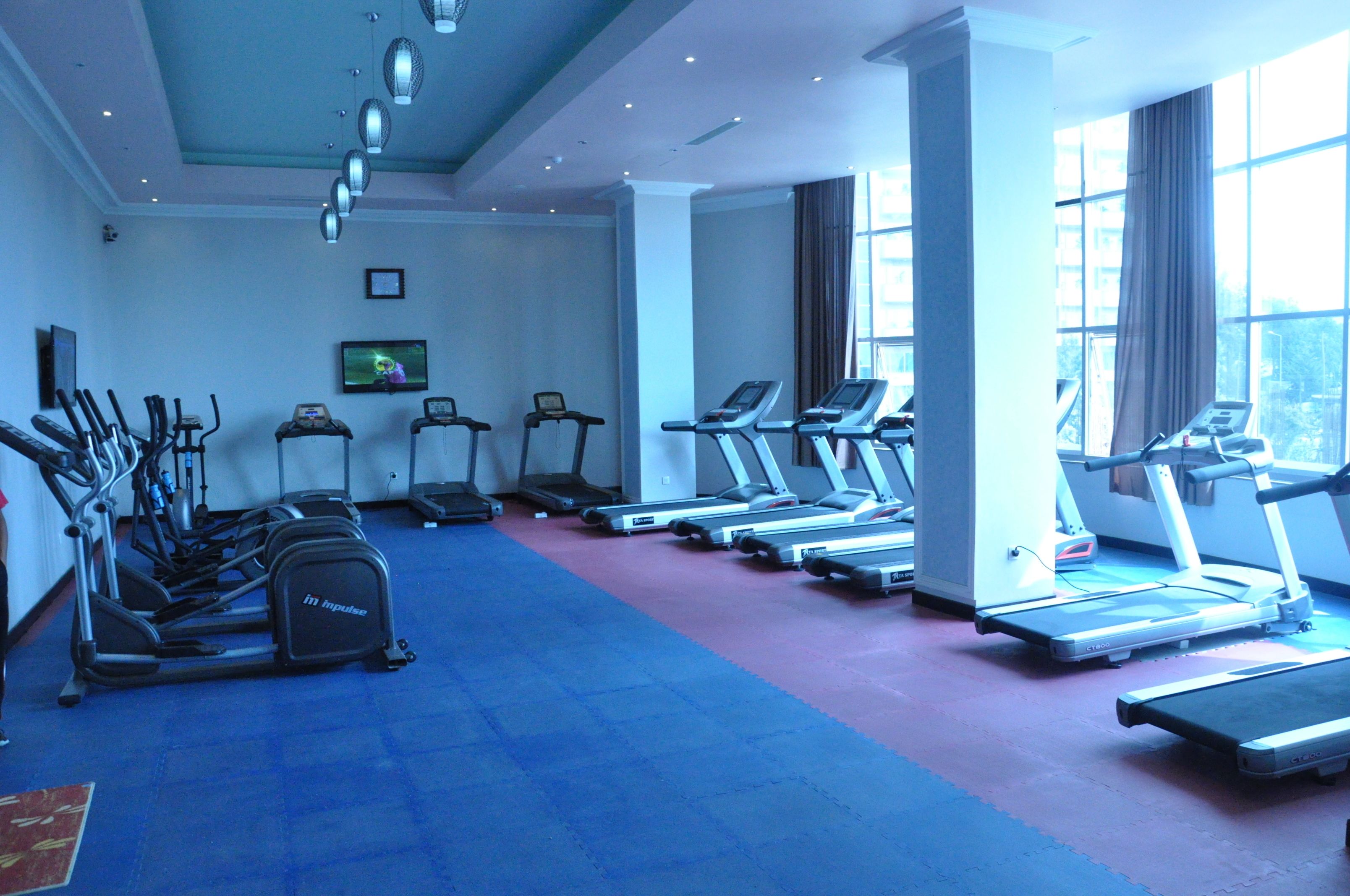 Een sportschool met loopbanden, elliptische trainers en hometrainers.
