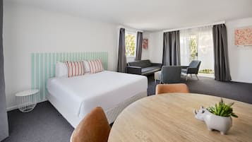 Escritorio, cortinas blackout y tabla de planchar con plancha