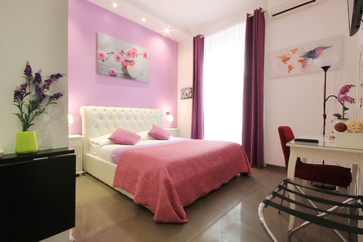 A bedroom with a bed, a desk, and a chair.