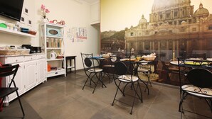 Comedor con vista a un edificio histórico, muebles de cocina blancos y un televisor.