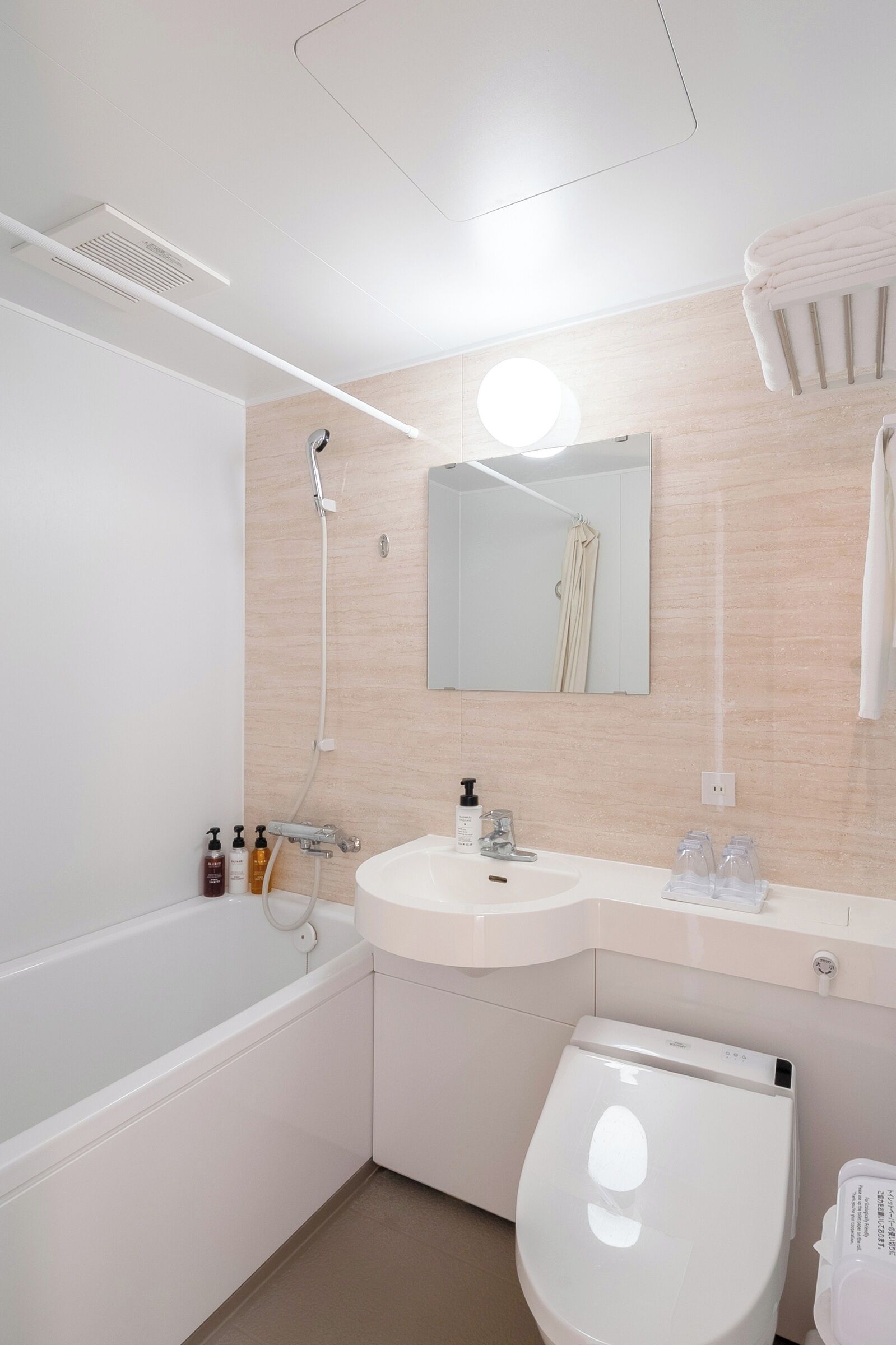 A modern bathroom with a bathtub, a toilet, a sink, and a mirror.