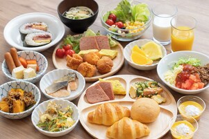 Variedad de platos, como sushi, croissants y una ensalada.