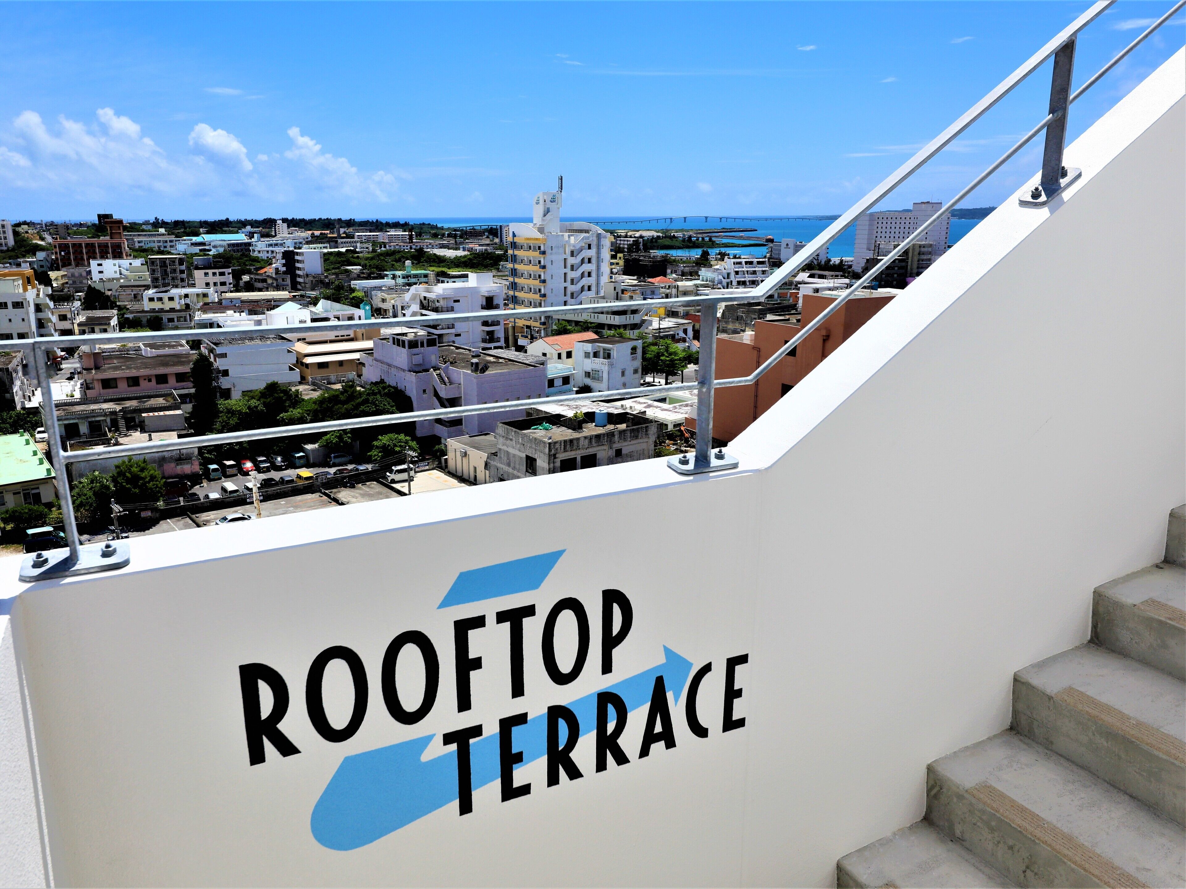 Blick von der Dachterrasse eines Gebäudes, auf dem ein Schild mit der Aufschrift 'ROOFTOP TERRACE' steht.
