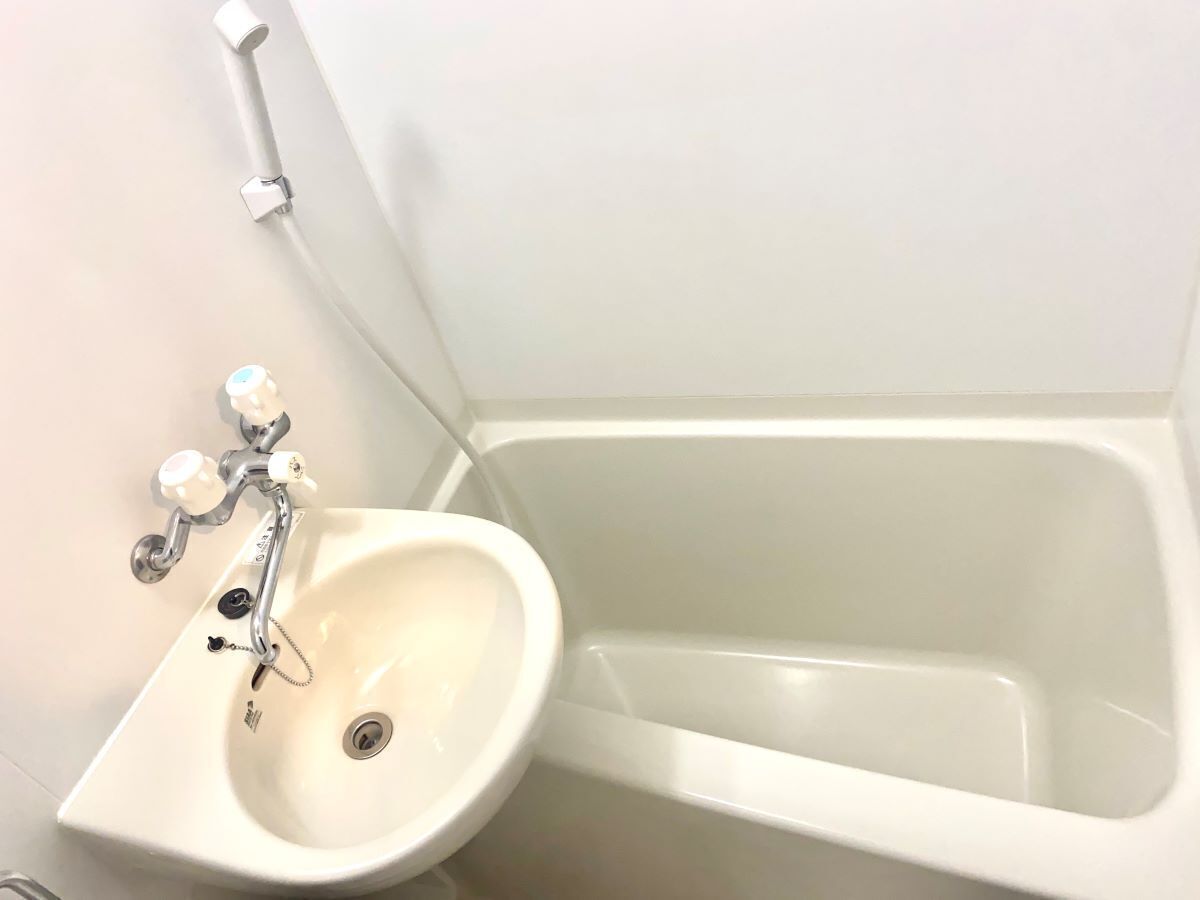 Ein Badezimmer mit weißem Waschbecken und Badewanne.
